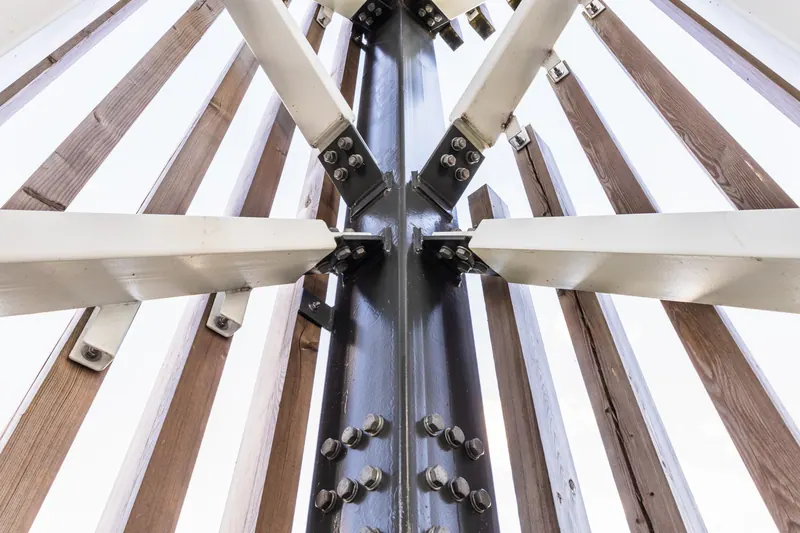 A steel column with bolted bracing members meeting at a gusseted connection, seen from below.